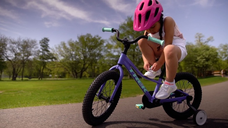 A kid sitting on a Trek Precaliber 16 bicycle, one of the kid-focused models affected by Trek's product recall