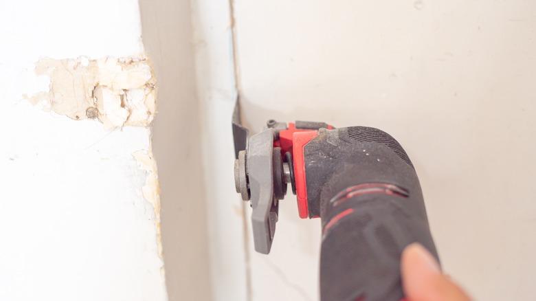 Person using multi-tool to cut drywall