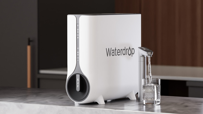 The K6 under-sink RO system sitting on a marble countertop next to a faucet of running water