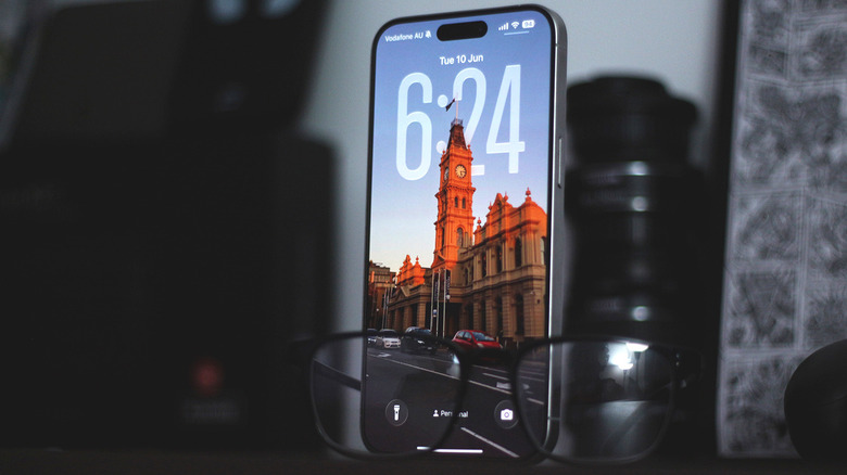 iPhone lock screen with Liquid Glass elements