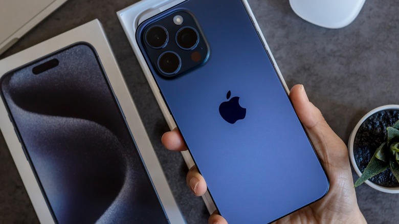 hand holding blue iPhone 15 