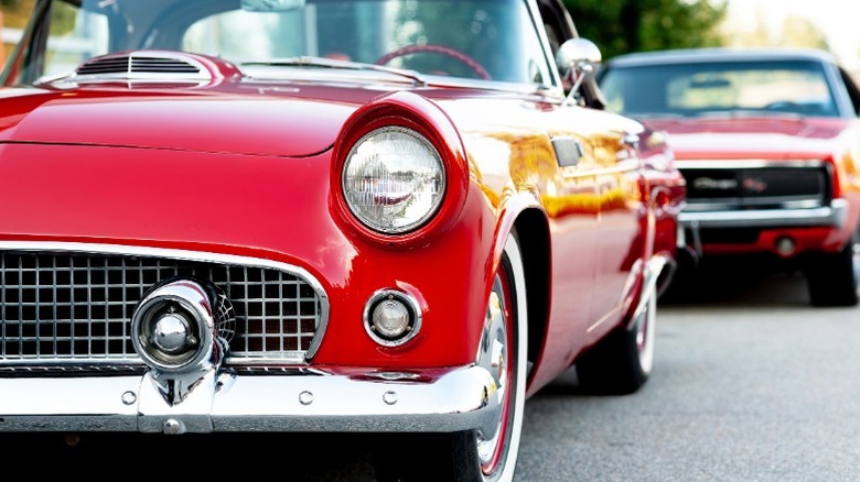 two classic red cars parked near each other