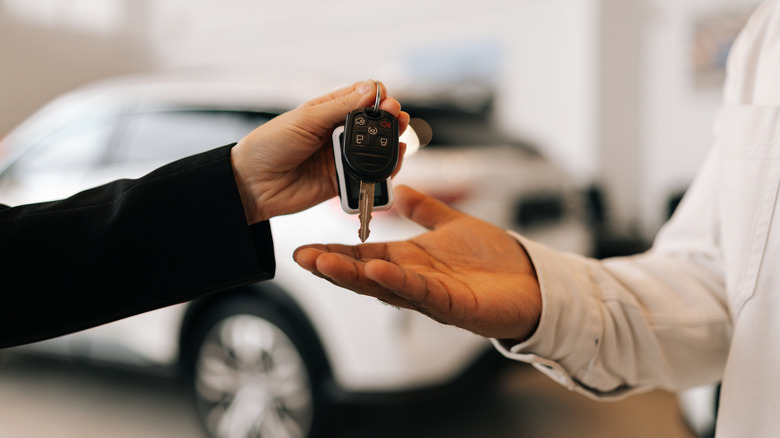 Person getting keys to car at dealership