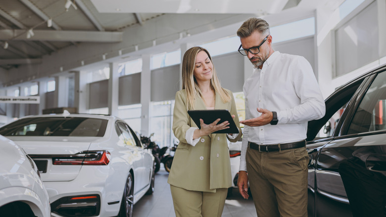 Man reviewing documents in car dealership
