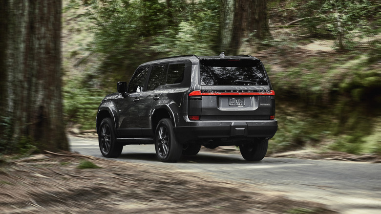 Rear quarter shot of a 2024 Lexus GX 550 in gray on a forest road