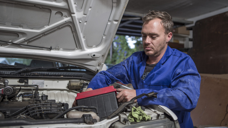 Man moving car battery