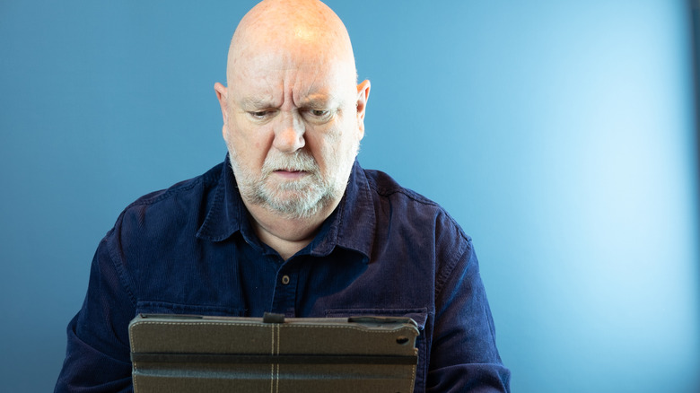 Man using tablet - photo warning of online scams