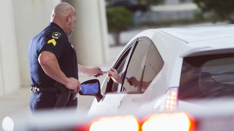 A police officer giving a driver a ticket