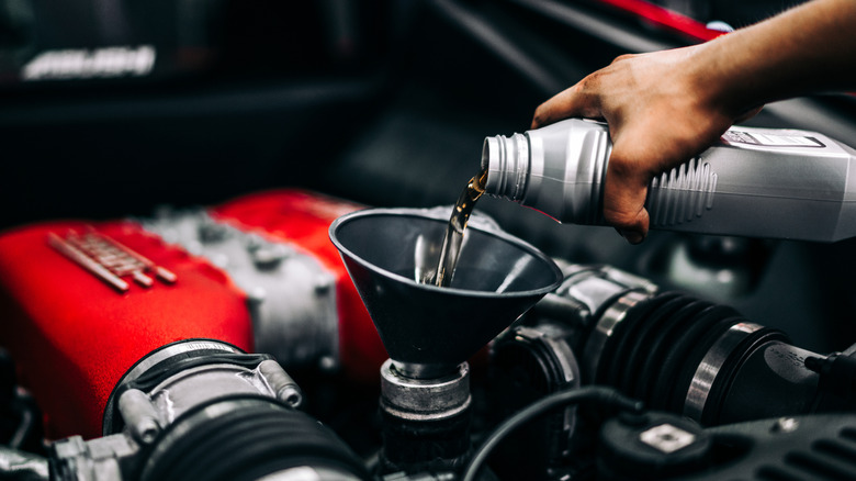 Person changing oil on a Ferrari engine