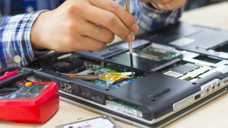 A person repairing a laptop.