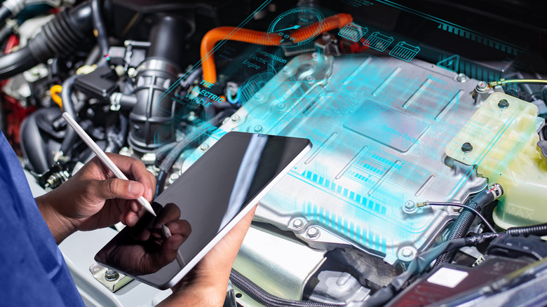 Technician using a tablet to analyze and diagnose a vehicle