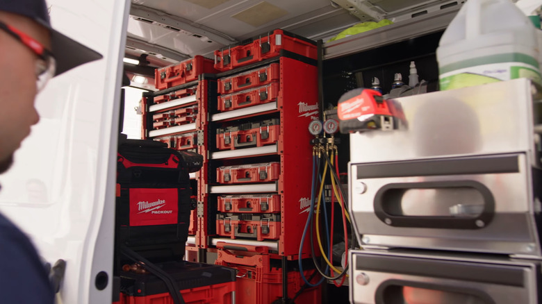 Person looking into a van equipped with Milwaukee Packout Rack Kits