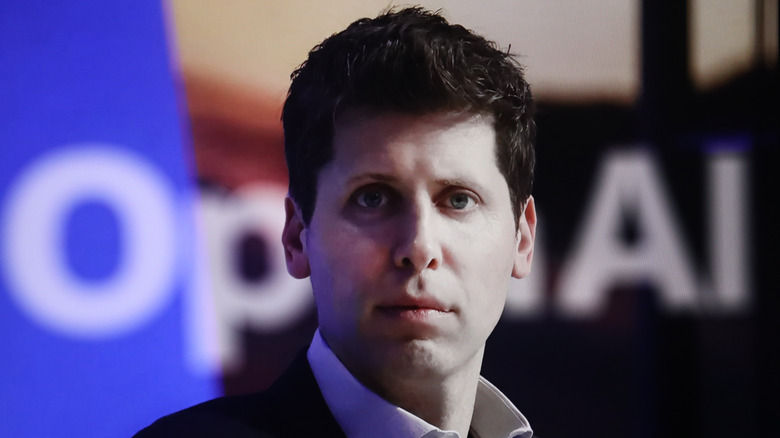 OpenAI CEO Sam Altman in front of a blurred background which says 