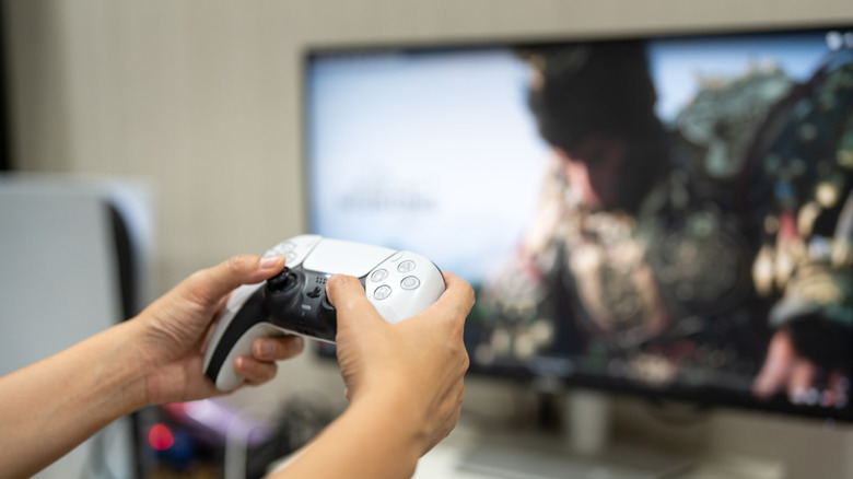 A gamer is controlling on PlayStation 5 joy stick, ready to playing a game.