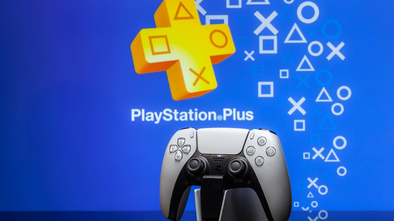 White new Playstation 5 gamepad with Playstation Plus on screen on a blue background.