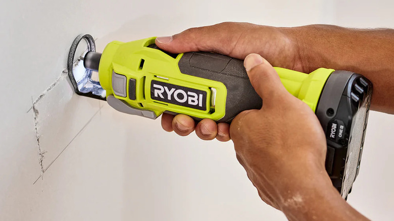 Person uses Ryobi's 18V Cut-Out Tool on drywall