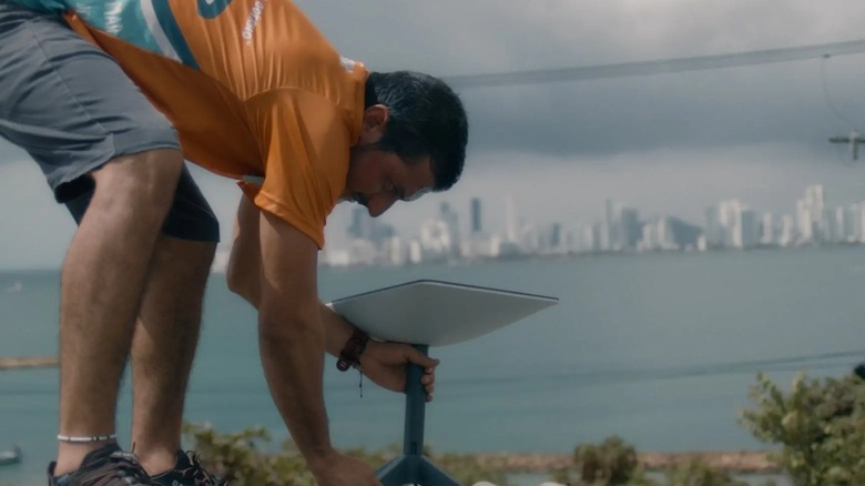 Man installing Starlink dish outside