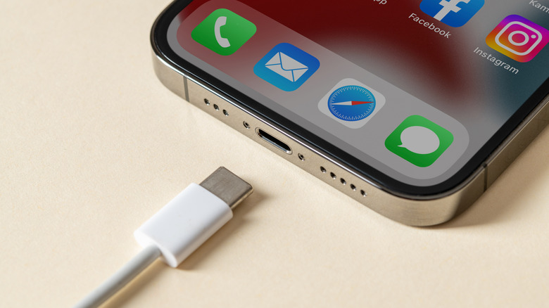 An iPhone sitting unplugged next to a USB-C charging cable