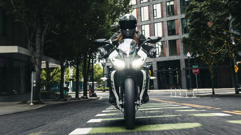 Frontal view of a person riding a CFMoto 300SS through the city
