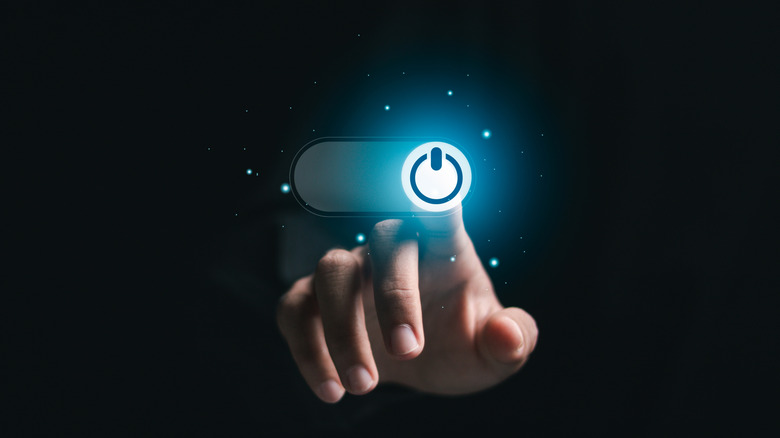 Person pressing power button with their finger