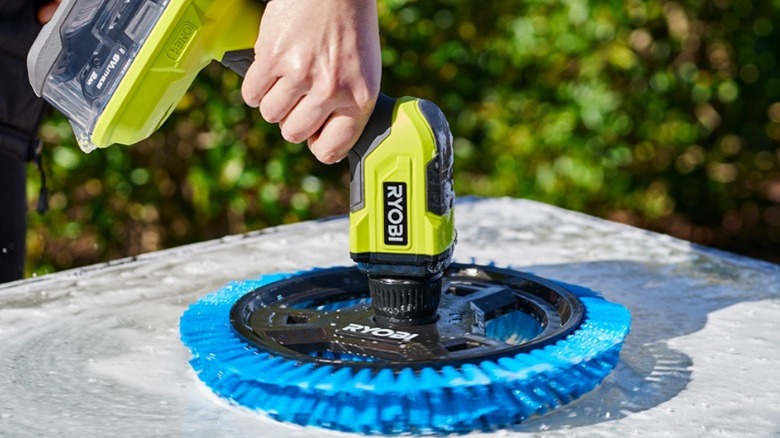Person using Ryobi Power Scrubber on outdoor surface