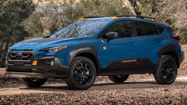 Subaru Crosstrek Wilderness parked on a dirt road with trees in the background