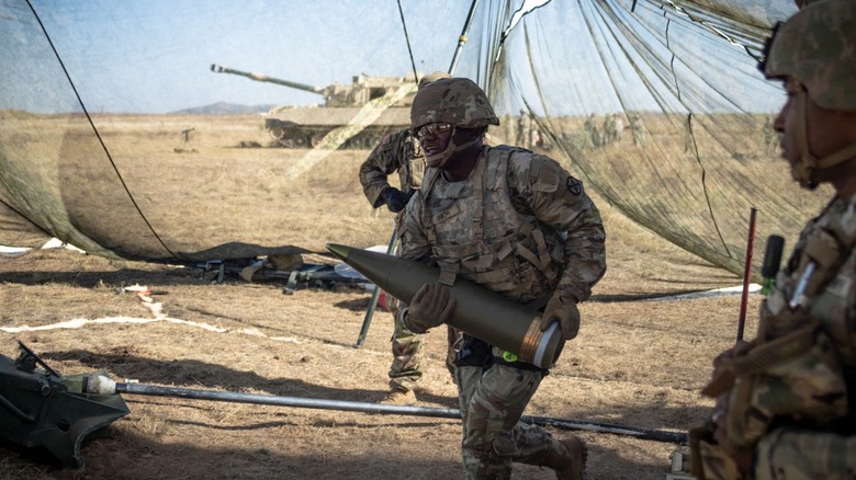 A soldier carried a howitzer shell while testing a powered exoskeleton