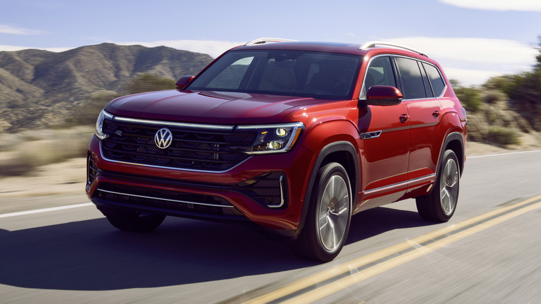 2024 Volkswagen Atlas driving on a road with mountains in the background