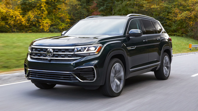 2022 VW Atlas driving on a road with trees and lush green grass in the background