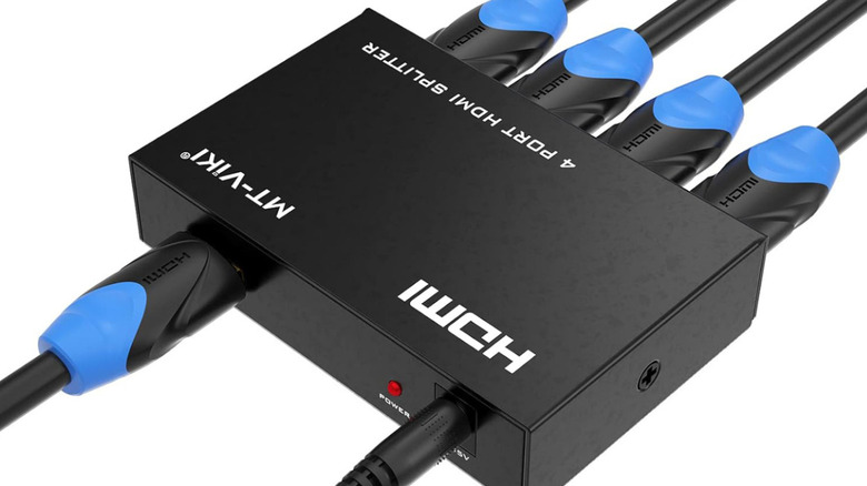 Boxy black 4-port HDMI splitter with cables in all ports