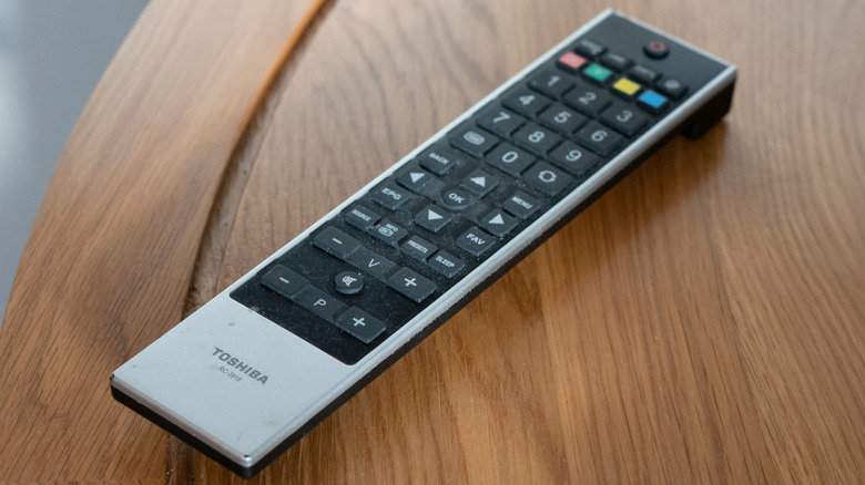 A Toshiba TV remote controller on a wooden table