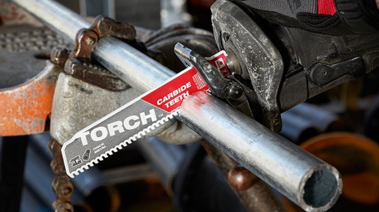 Person using reciprocating saw to cut metal pipe