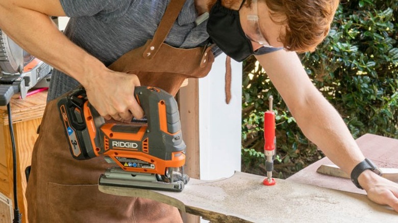 Person cutting curve in wood with a jigsaw
