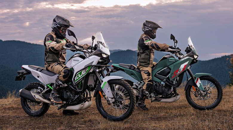 Two Kawasaki KLE500 motorcycles parked in a field