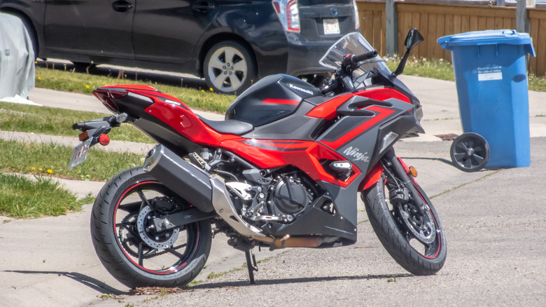 A Kawasaki Ninja 500 motorcycle is parked on the side of a road