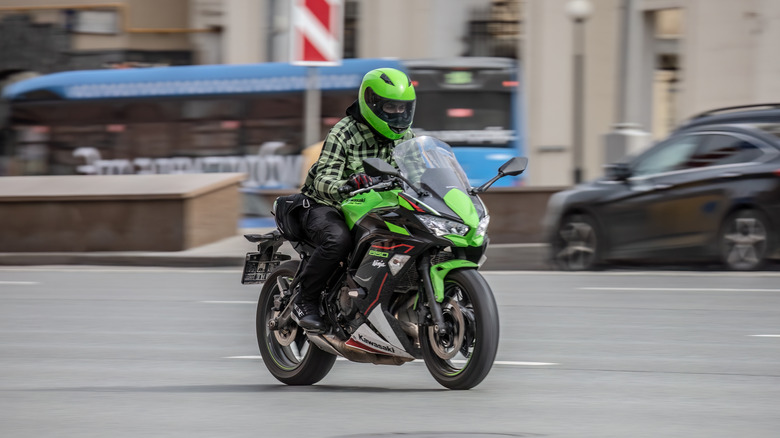 A man riding Kawasaki Ninja 650 motorbike on city road