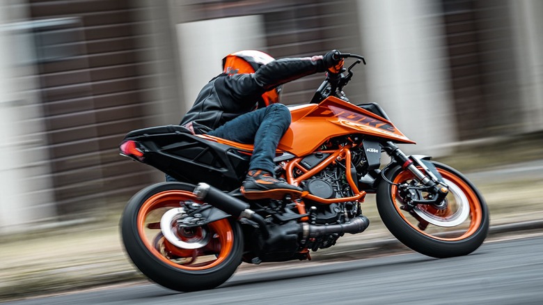 An image of a 2025 KTM 390 Duke racing past buildings