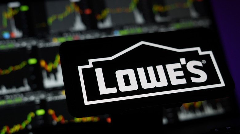 Lowe's Logo On Mobile And Computer Screens With Stock Chart Background