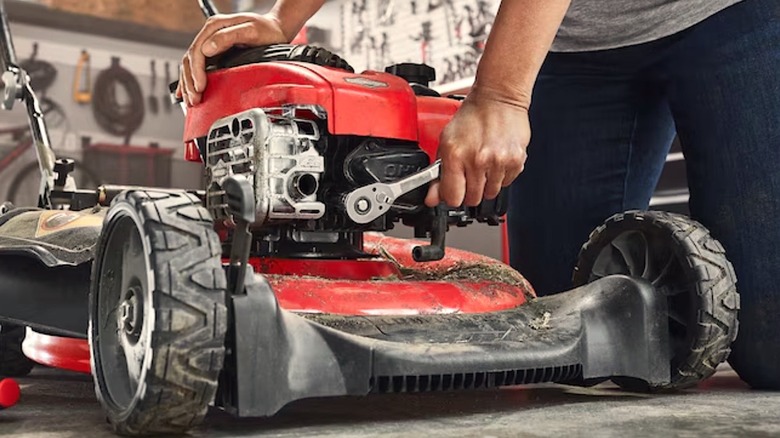 Person using Craftsman tool to fix lawnmower
