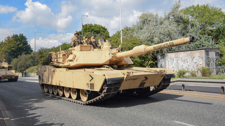 M1A1 Abrams tank driving down a road during a military parade in Poland.