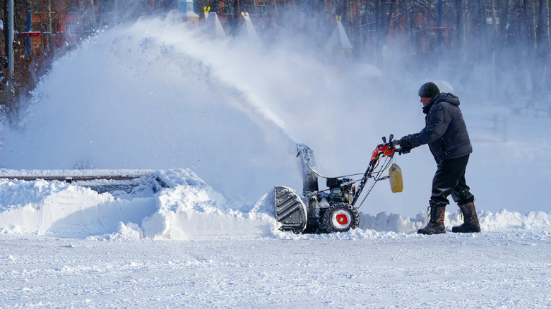 An image of a person plowing snow in a Venture Heat heated jacket