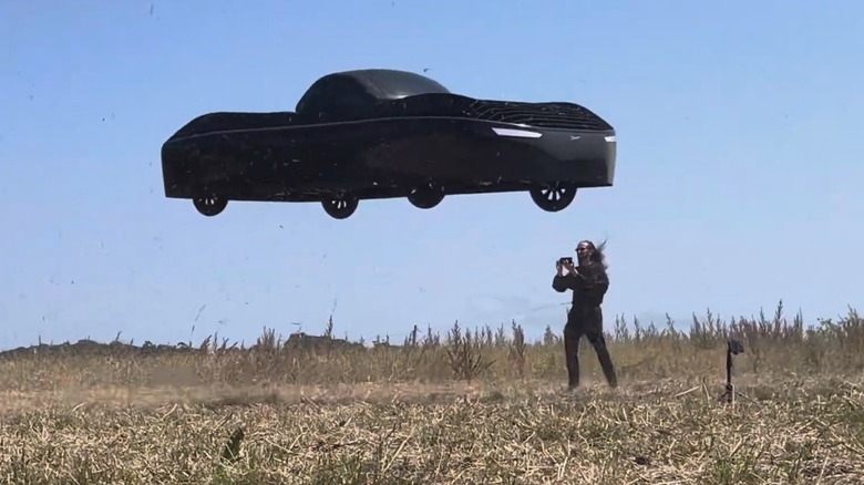 The CEO of Alef Aeronautics next to a Model A which is hovering in the air