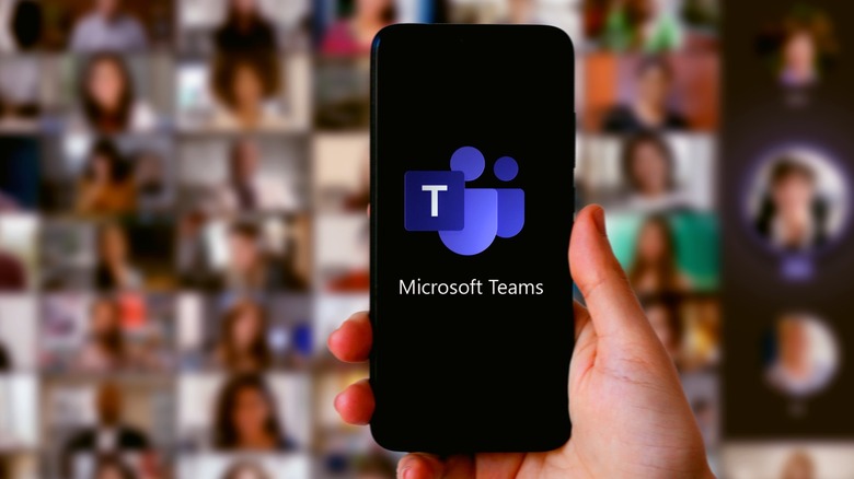 Microsoft Teams logo on a phone in front of a Microsoft Teams meeting on a screen