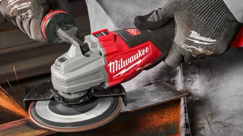 Person grinding pipe with Milwaukee Dual-Trigger Braking Grinder