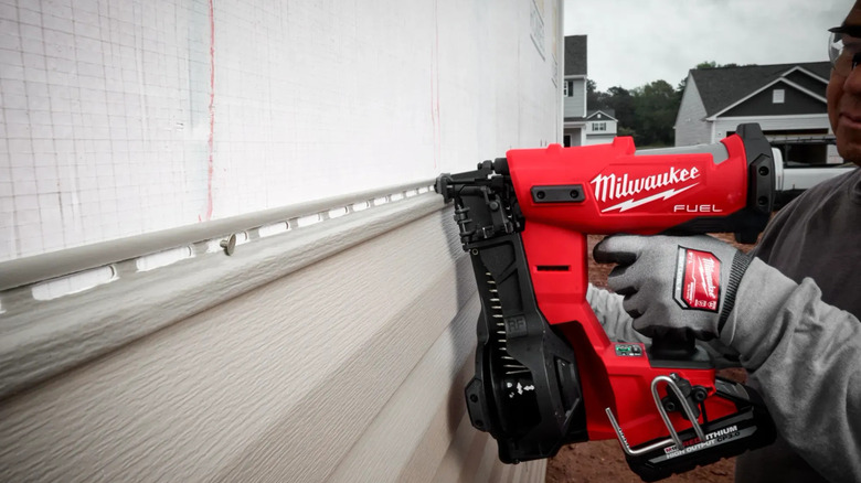 M18 Fuel Coil Roofing Nailer in use on vinyl siding
