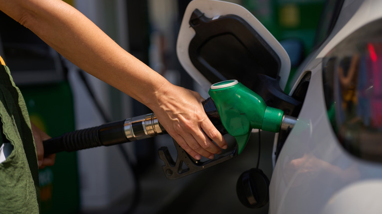 Driver filling car with diesel gas pump