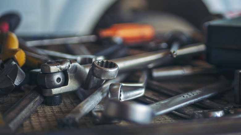 A pile of hand tools on a table.