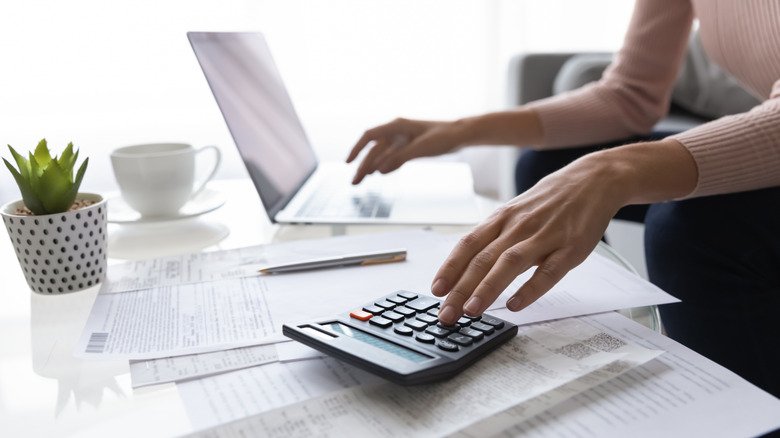 Person using laptop and calculator