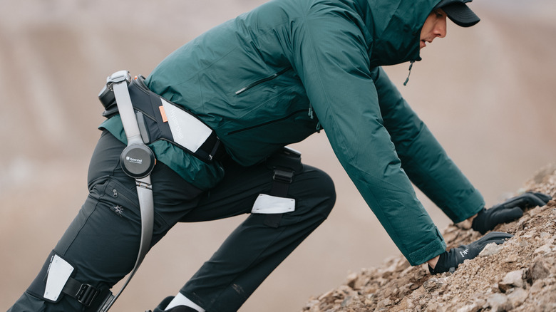 An outdoorsman traverses rugged terrain with a Hypershell X