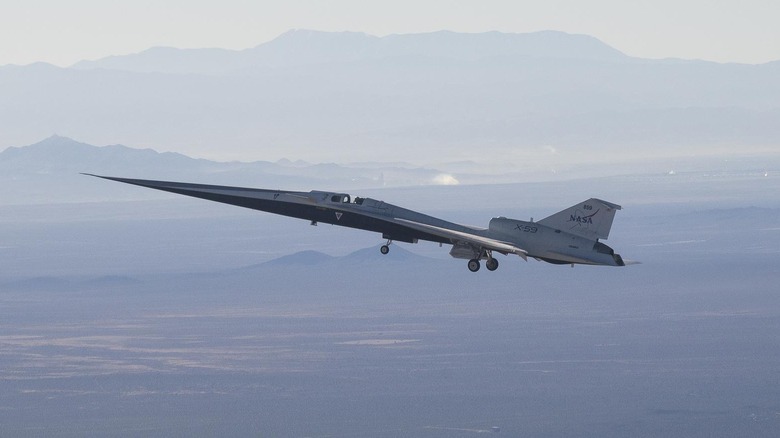 NASA and Lockheed Martin's supersonic X-59 prototype in the air with mountains in the background